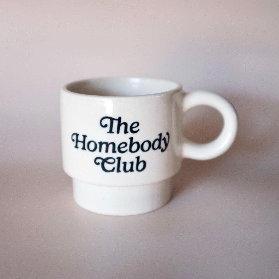 White mug with 'The Homebody Club' text