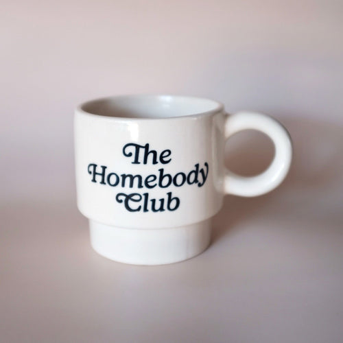 White mug with 'The Homebody Club' text